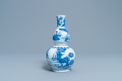 A Chinese blue and white double gourd vase with figures in a landscape, Transitional period