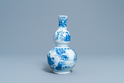 A Chinese blue and white double gourd vase with figures in a landscape, Transitional period