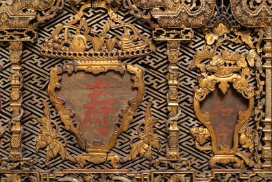 A Chinese carved and gilt wooden panel with red painted characters, 18/19th C.