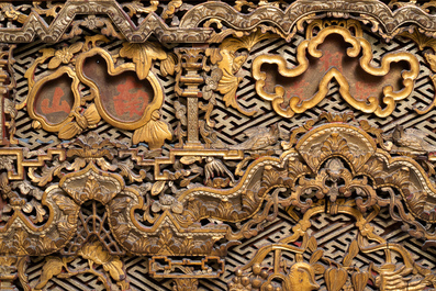 A Chinese carved and gilt wooden panel with red painted characters, 18/19th C.