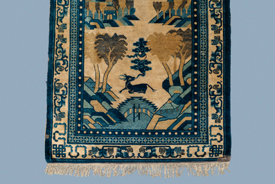 A rectangular Chinese Beijing silk carpet with a deer in a landscape, 19th C.