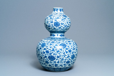 A large Chinese blue and white double gourd vase with floral scrolls, 19/20th C.