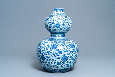 A large Chinese blue and white double gourd vase with floral scrolls, 19/20th C.