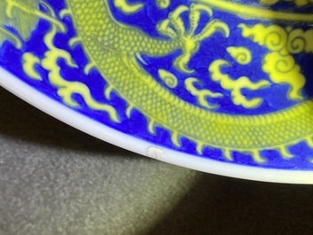Un plat en porcelaine de Chine en bleu et jaune &agrave; d&eacute;cor d'un dragon, marque et &eacute;poque de Qianlong