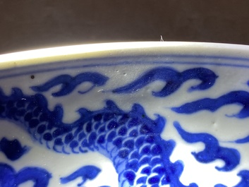 Un plat en porcelaine de Chine en bleu et blanc &agrave; d&eacute;cor d'un dragon, marque et &eacute;poque de Kangxi