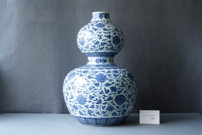 A large Chinese blue and white double gourd vase with floral scrolls, 19/20th C.