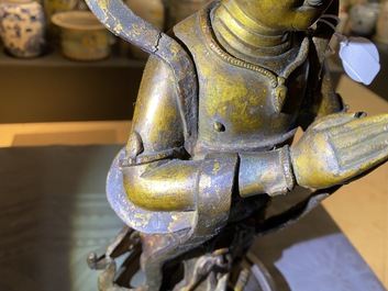 Een Chinese gelakte en vergulde bronzen figuur van een dienaar, Ming