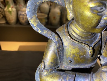 Een Chinese gelakte en vergulde bronzen figuur van een dienaar, Ming