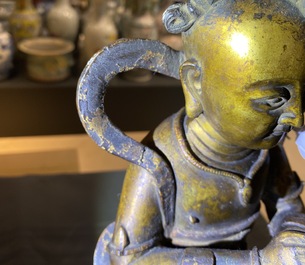 Een Chinese gelakte en vergulde bronzen figuur van een dienaar, Ming