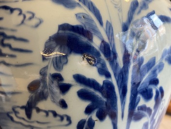 Een Chinese blauw-witte vaas met figuren in een interieur, Kangxi