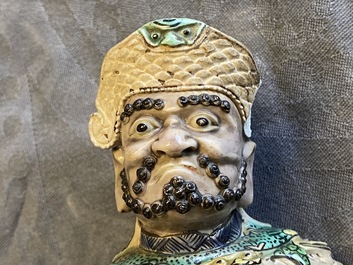 A Chinese verte biscuit figure of a Guandi, Kangxi