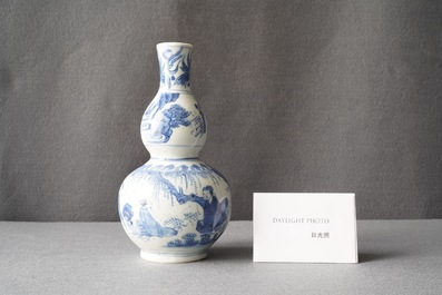 A Chinese blue and white double gourd vase with figures in a landscape, Transitional period