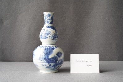 A Chinese blue and white double gourd vase with figures in a landscape, Transitional period