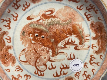 Une assiette en porcelaine de Chine en bleu, blanc et rouge de fer &agrave; d&eacute;cor de lions bouddhistes, marque de Qianlong, 19&egrave;me