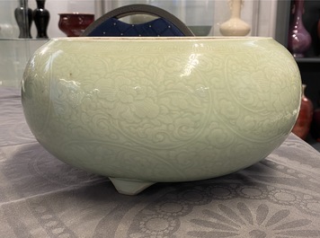 Een Chinese monochrome celadon driepotige wierookbrander met onderglazuur floraal decor, Kangxi