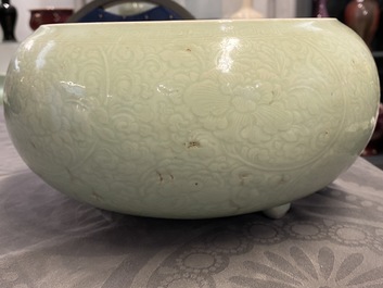 Een Chinese monochrome celadon driepotige wierookbrander met onderglazuur floraal decor, Kangxi