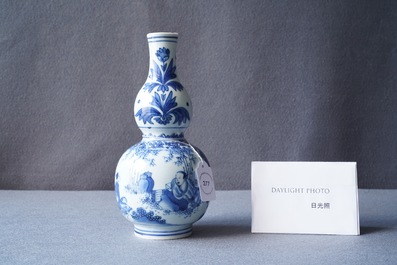 A Chinese blue and white double gourd vase with figures in a landscape, Transitional period