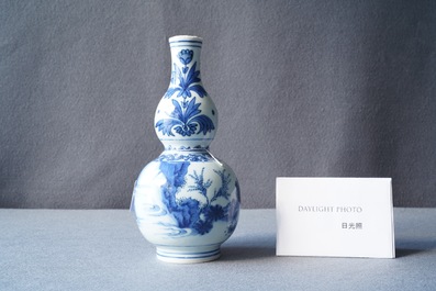 A Chinese blue and white double gourd vase with figures in a landscape, Transitional period