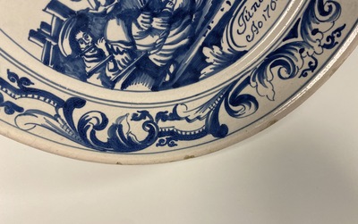 A Dutch Delftware blue and white dish with soldiers at camp, Makkum, dated 1764