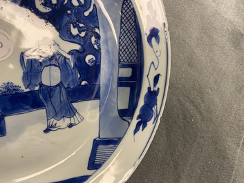 A Chinese blue and white dish with two figures in a garden, Transitional period