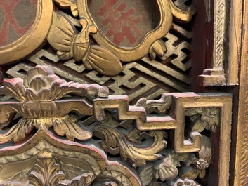 A Chinese carved and gilt wooden panel with red painted characters, 18/19th C.