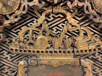 Een Chinees gestoken en verguld houten paneel met rode karakters beschilderd, 18/19e eeuw
