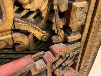 A Chinese carved and gilt wooden panel with red painted characters, 18/19th C.