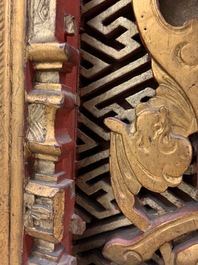 A Chinese carved and gilt wooden panel with red painted characters, 18/19th C.