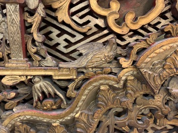 Een Chinees gestoken en verguld houten paneel met rode karakters beschilderd, 18/19e eeuw