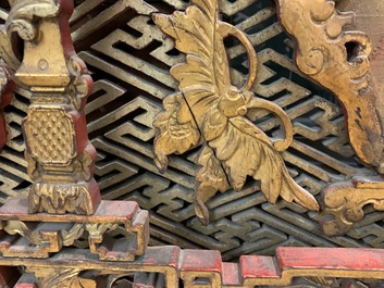 A Chinese carved and gilt wooden panel with red painted characters, 18/19th C.