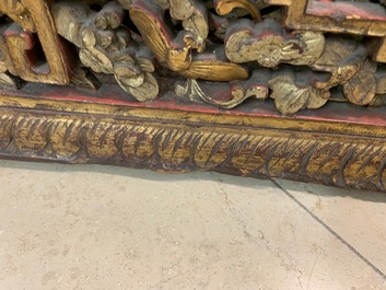 A Chinese carved and gilt wooden panel with red painted characters, 18/19th C.