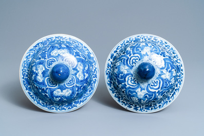 A pair of Chinese blue and white covered vases with landscape medallions on a floral ground, Kangxi