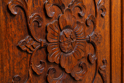 A Chinese wooden two-door cupboard with carved floral panels, 19th C.