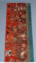 A large Chinese horizontal embroidered red-ground textile panel, 19th C.