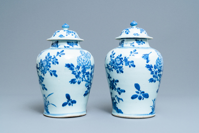 A pair of Chinese blue and white baluster vases and covers with birds in a rocky landscape, Kangxi