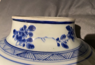 A pair of Chinese blue and white baluster vases and covers with birds in a rocky landscape, Kangxi