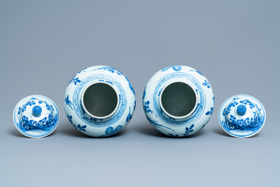 A pair of Chinese blue and white baluster vases and covers with birds in a rocky landscape, Kangxi