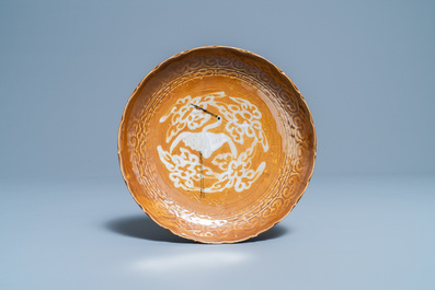 Une assiette en porcelaine de Chine &agrave; d&eacute;cor d'une grue sur fond brun, fours de Swatow, Ming