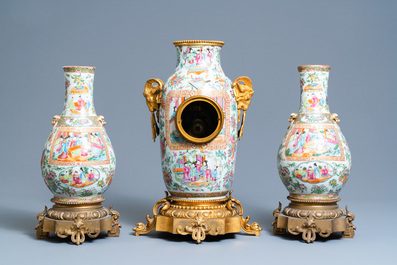 A Chinese gilt bronze-mounted three-piece Canton famille rose clock garniture, 19th C.