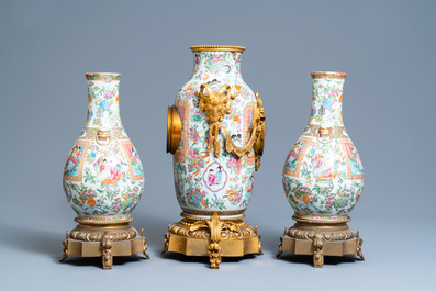 Une garniture de trois pi&egrave;ces en porcelaine de Chine famille rose de Canton mont&eacute;e en pendule en bronze dor&eacute;, 19&egrave;me