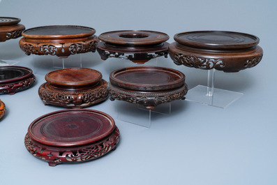 Fourteen Chinese reticulated round carved wooden stands, 19/20th C.