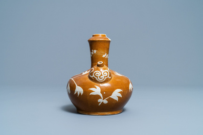 Een zeldzame Chinese Swatow kendi met floraal decor op bruine fondkleur, Ming