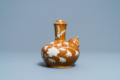 Un kendi en porcelaine de Chine &agrave; d&eacute;cor floral sur fond brun, fours de Swatow, Ming