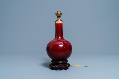 Un vase de forme bouteille en porcelaine de Chine sang de boeuf monochrome mont&eacute; en lampe, 19/20&egrave;me
