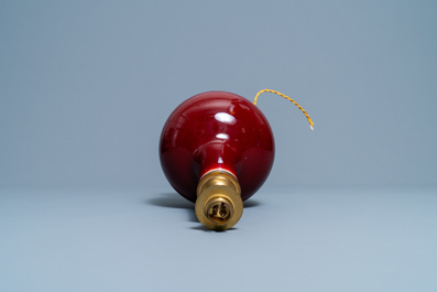 Un vase de forme bouteille en porcelaine de Chine sang de boeuf monochrome mont&eacute; en lampe, 19/20&egrave;me