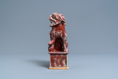 Un mod&egrave;le d'un lion bouddhiste en porcelaine de Chine sang de boeuf monochrome, 19&egrave;me