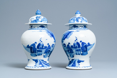 A pair of Chinese blue and white vases and covers with figures in a landscape, 19th C.