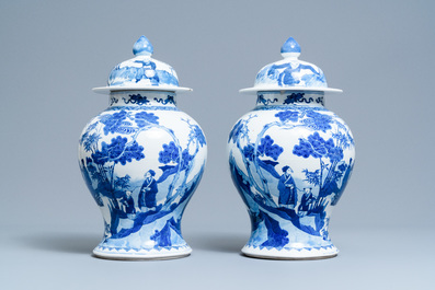 A pair of Chinese blue and white vases and covers with figures in a landscape, 19th C.