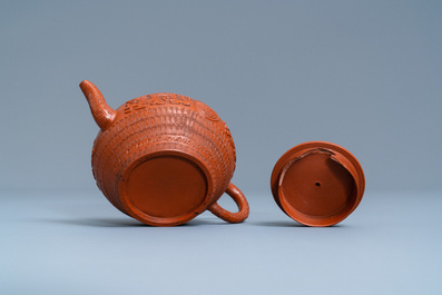 A Chinese Yixing stoneware teapot and cover with applied and impressed design, Kangxi