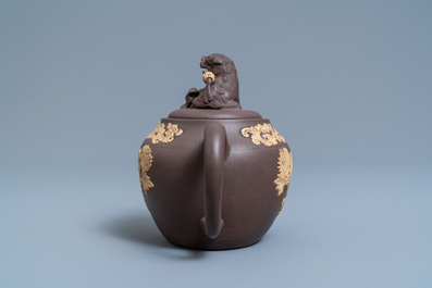 A bichrome Chinese Yixing stoneware teapot and cover with applied floral design, Kangxi